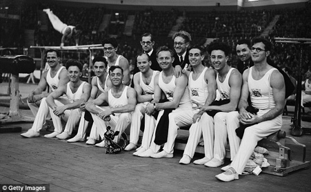 GB Men’s team in the competition hall, 9 gymnasts are shown here in The Empress Hall. The three men together in spectacles are left to right, Ken Buffin, Bill King and Helmut Bantz. In front of Helmut is Arthur Whitford. Jack Whitford who broke his arm before the event so did not compete is not shown 