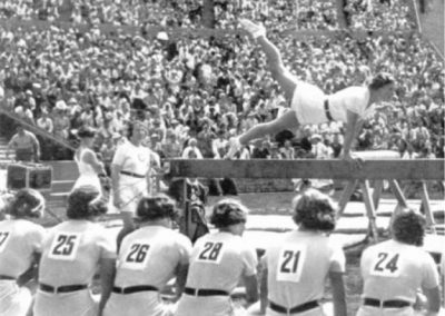 The Polish team on beam performing before a packed stadium