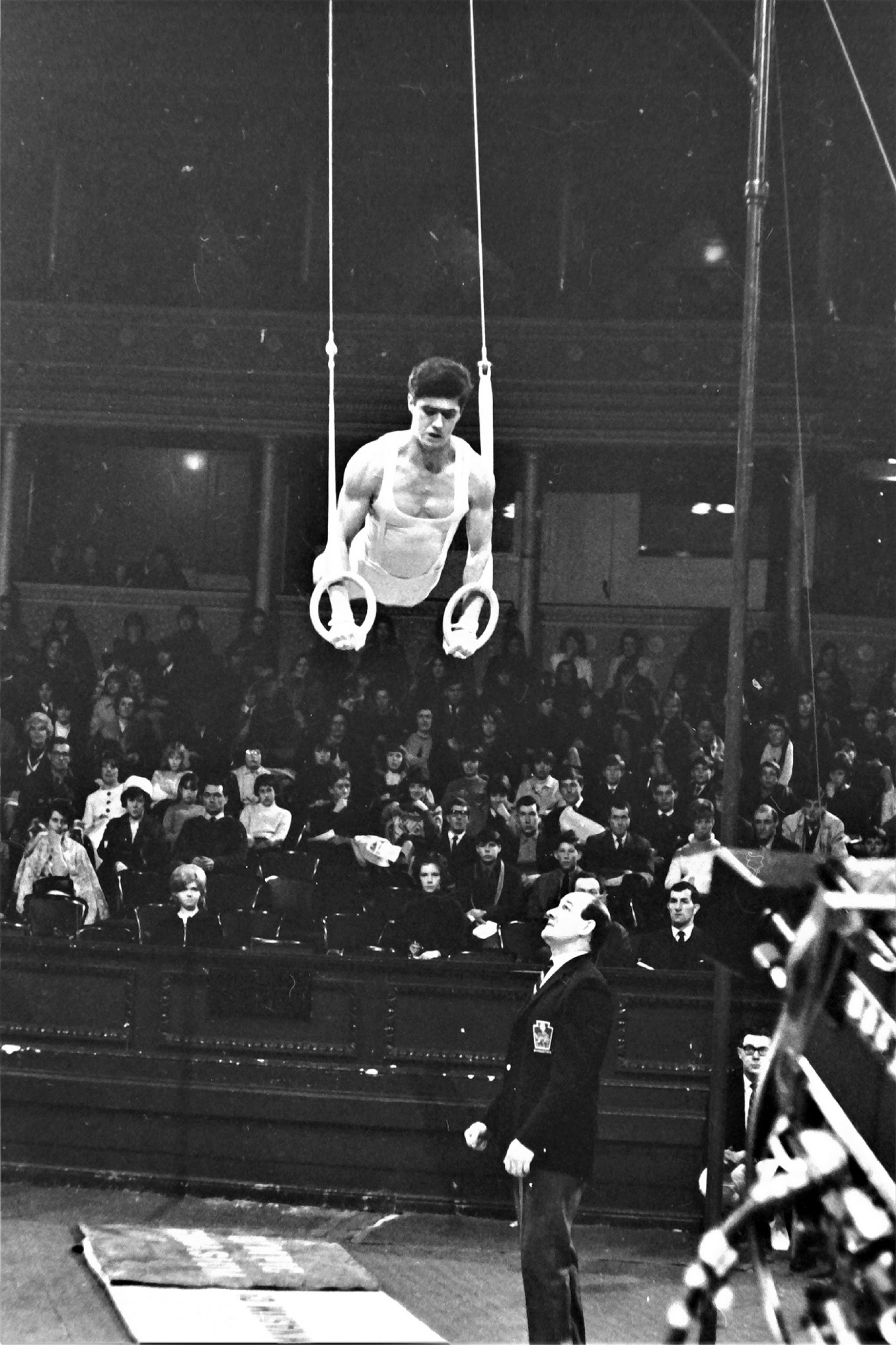 Mike Booth competing on Rings at the British Gymnastics Championships in 1966 with dad and coach Stan Booth standing by - Photo Alan Burrows